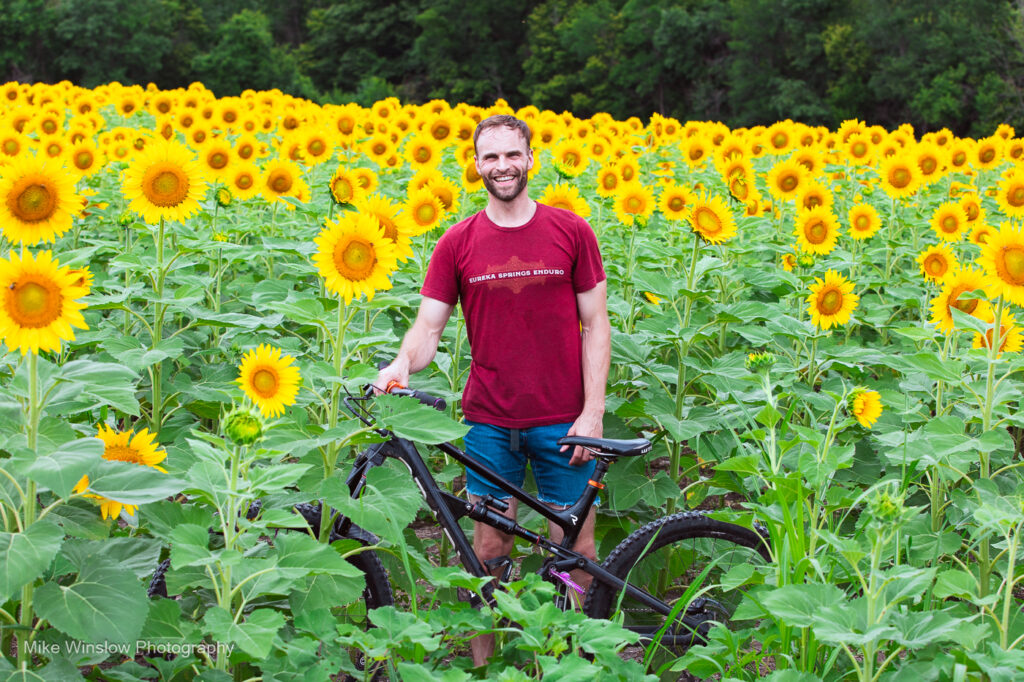 man, bike in sunflower field